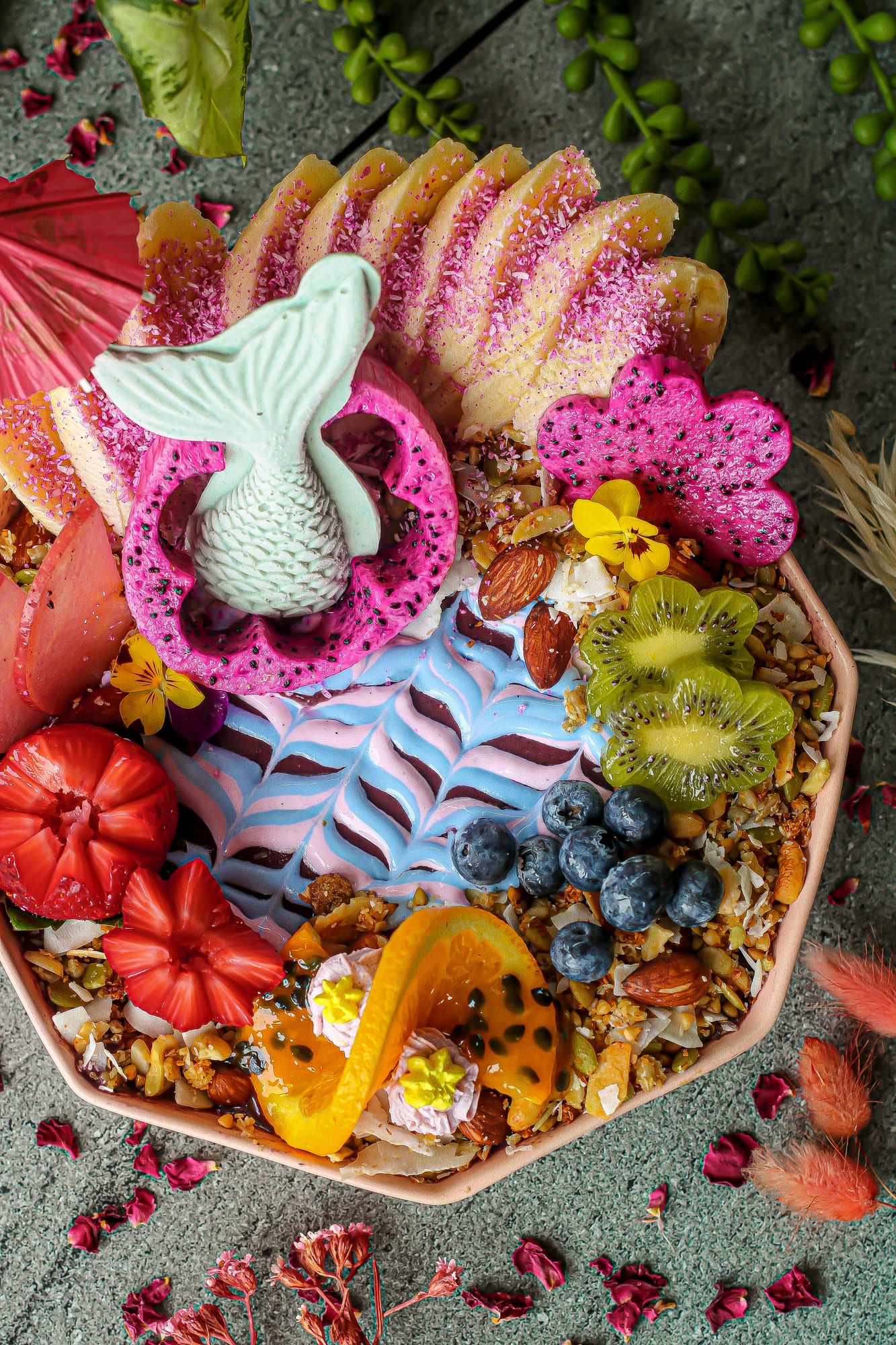 Vibrant vegan acai smoothie bowl with dragon fruit, banana, kiwi, blueberries, strawberries and granola