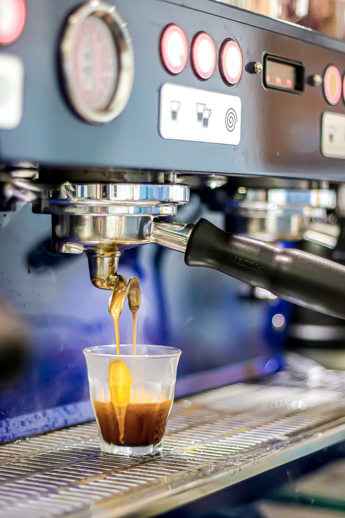 Fresh espresso pouring from the coffee machine into a glass at The Cardamom Pod