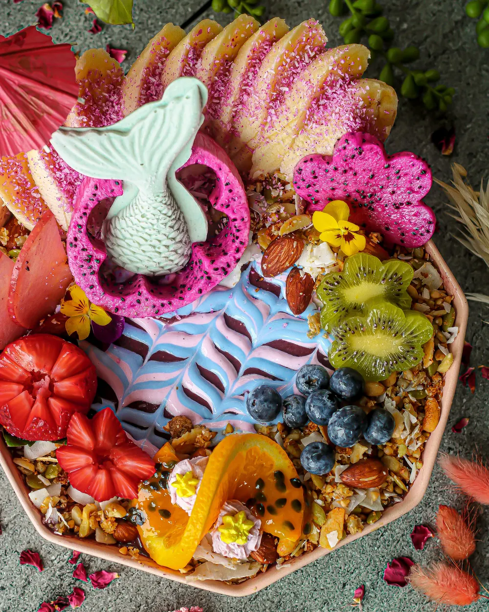 A loaded acai bowl with dragonfruit, kiwi, blueberries, strawberries and granola