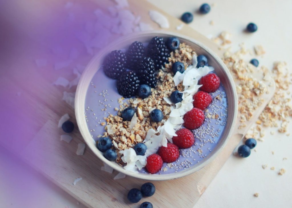 A colourful smoothie bowl with toppings, overhead view
